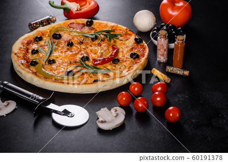 Tasty fresh hot pizza against a dark background 60191378