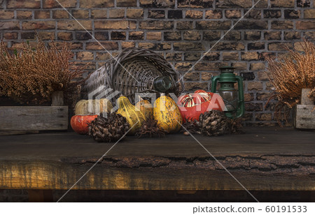 Autumn still life. Pumpkins on an old wooden table against the background of an old brick wall 60191533