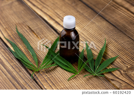 hemp oil on a wooden background. Marijuana hemp oil on a wooden background. Marijuana 60192420