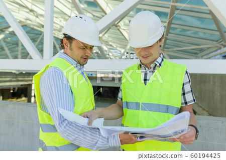 Male construction worker and engineer at the construction site. Building, development, teamwork and people concept 60194425