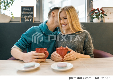 Young happy couple in love in cafe, young man and woman together smile hugging drink coffee tea Young happy couple in love in cafe, young man and woman together smile hugging drink coffee tea 60194842