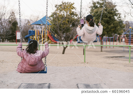 在鞦韆上玩一個女孩的背影 在鞦韆上玩一個女孩的背影 60196045