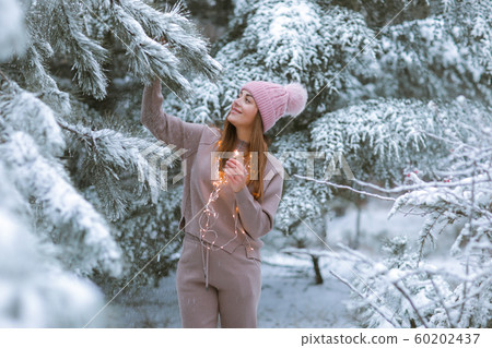 Woman in winter on a snowy street in the woods Woman in winter on a snowy street in the woods 60202437