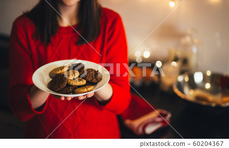 Happy woman in Santa hat cooking Christmas cookies Happy woman in Santa hat cooking Christmas cookies 60204367