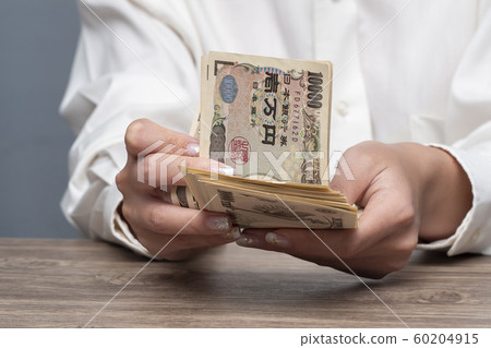 Close up female hand counting Japanese yen banknotes Close up female hand counting Japanese yen banknotes 60204915