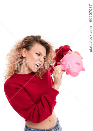 cheeky attractive girl with a piggy bank in hands on a white studio background 60207087