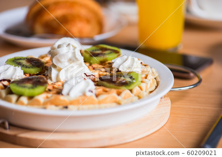 Belgian waffles juice and croissant on a table. Belgian waffles juice and croissant on a table. 60209021