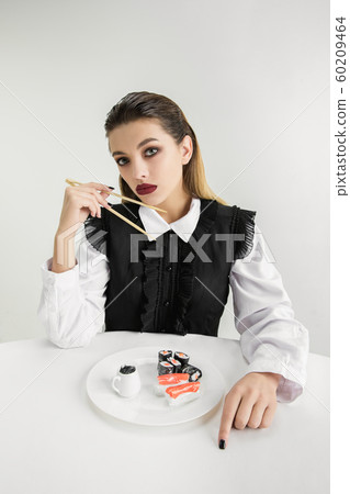 We are what we eat. Woman's eating plastic food, eco concept 60209464
