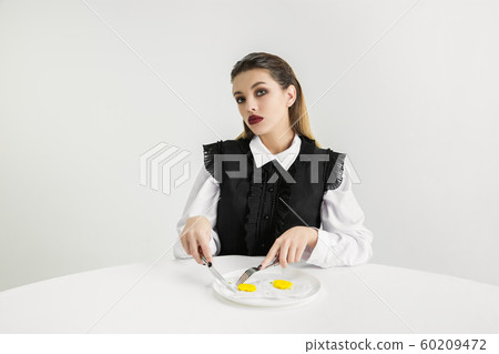 We are what we eat. Woman's eating plastic food, eco concept 60209472