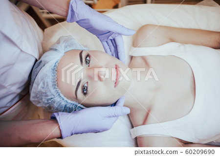 Cosmetology doctor makes woman treatments facial massage Cosmetology doctor makes woman treatments facial massage 60209690