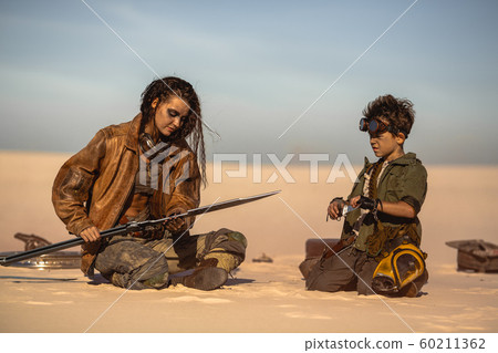 Post Apocalyptic Woman and Boy with Weapons Outdoors in the Wasteland Post Apocalyptic Woman and Boy with Weapons Outdoors in the Wasteland 60211362