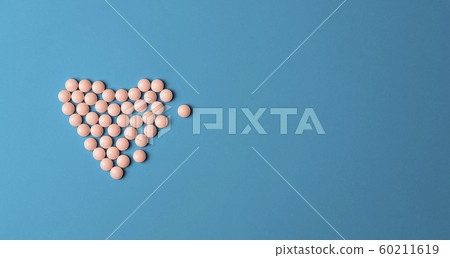 Medical background. Pink Pills in form of heart on blue background Medical background. Pink Pills in form of heart on blue background 60211619