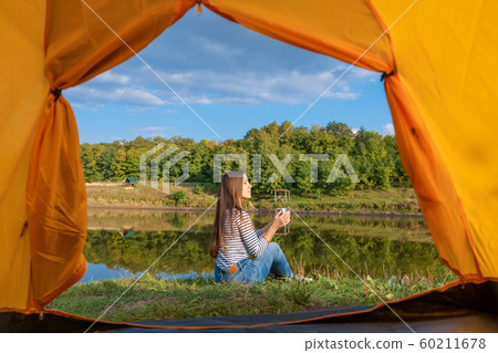 Camping on lake shore at sunset, view from inside 60211678