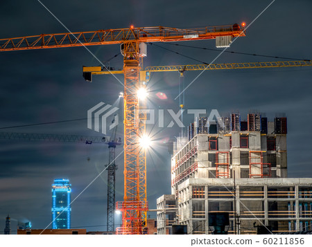 Tower cranes at a construction site in the night 60211856