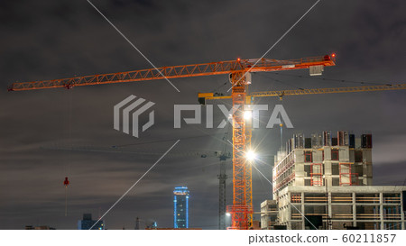 Tower cranes at a construction site in the night 60211857