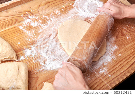 Kneaded dough on a rolling plate with spilled 60212451