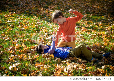 Two boys fighting outdoors. Friends wrestling in Two boys fighting outdoors. Friends wrestling in 60213873