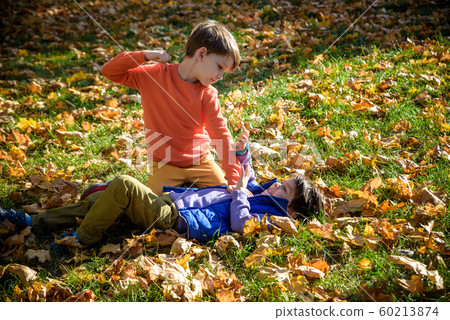 Two boys fighting outdoors. Friends wrestling in Two boys fighting outdoors. Friends wrestling in 60213874