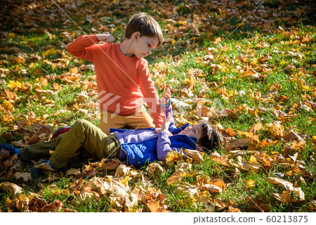 Two boys fighting outdoors. Friends wrestling in Two boys fighting outdoors. Friends wrestling in 60213875