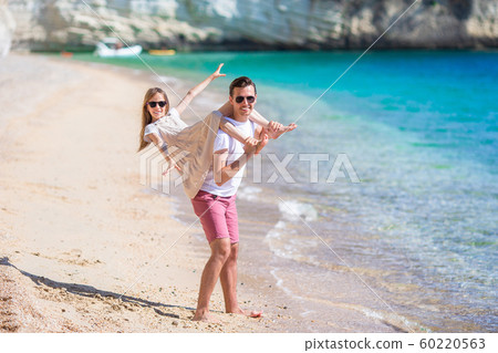 Little girl and happy dad having fun during beach vacation 60220563