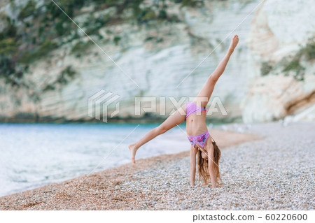 Adorable active little girl at beach during summer vacation 60220600