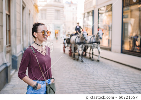 Woman walking in city. Young attractive tourist outdoors in italian city Woman walking in city. Young attractive tourist outdoors in italian city 60221557