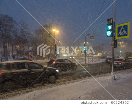 Night traffic of cars in the snow in the winter. 60224802