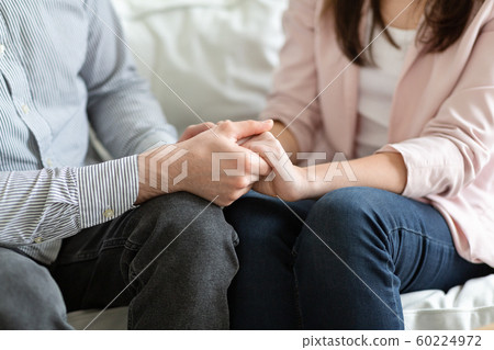 Married couple holding each other hands during family therapy Married couple holding each other hands during family therapy 60224972