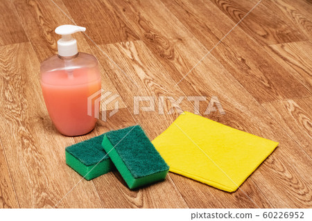 Cleaning agent, sponge and yellow rag on wooden Cleaning agent, sponge and yellow rag on wooden 60226952