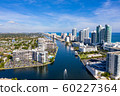 Aerial view of boat on Miami Beach canal with a flock of crows 60227364