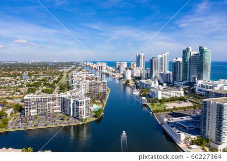 Aerial view of boat on Miami Beach canal with a flock of crows 60227364