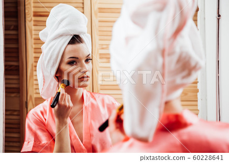 girl after shower makes makeup in the bathroom 60228641