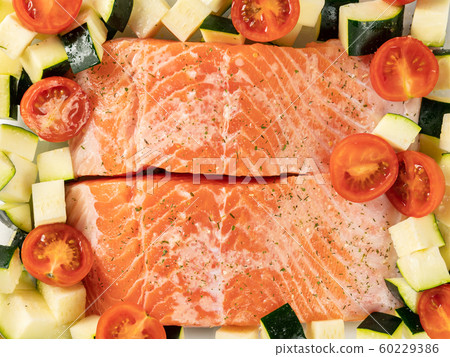 Raw salmon fillets pepper salt, seasonings and zucchini Raw salmon fillets pepper salt, seasonings and zucchini 60229386