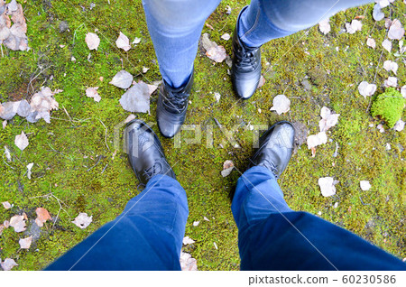 Boots of a man and a woman against a Boots of a man and a woman against a 60230586