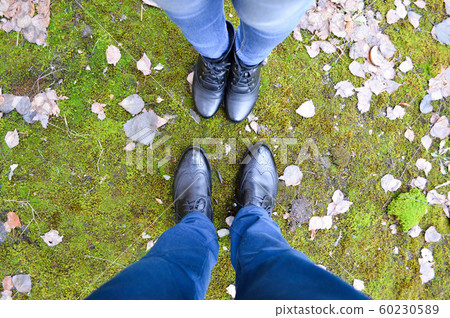 Boots of a man and a woman against a Boots of a man and a woman against a 60230589