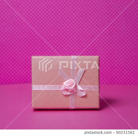 Photo of a gift box with a bow under points of view on a pink background front view 60231562