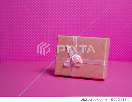 Photo of a gift box with a bow under points of view on a pink background front view Photo of a gift box with a bow under points of view on a pink background front view 60231584