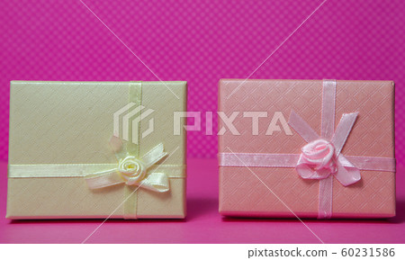 Photo of a gift box with a bow under points of view on a pink background front view Photo of a gift box with a bow under points of view on a pink background front view 60231586