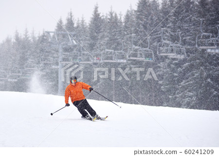 Adult male skiing during heavy snowfall. Monochrome view. Recreational outdoors sports vacation, leisure on solitude 60241209