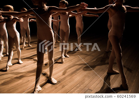 Pretty young girl and boy sitting on stage having stretching and training for ballet dances. 60241569
