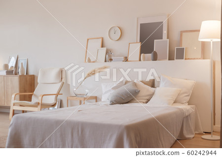 Bedroom interior with floor lamp and planty photoframes 60242944