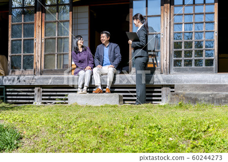 資深夫婦和女實業家談話在老房子的遠的邊 資深夫婦和女實業家談話在老房子的遠的邊 60244273
