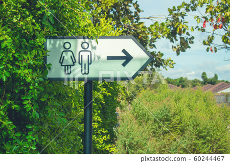 Metal toilet signs label on metal pole at outside building. 60244467