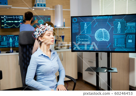 Female patient who is in a neurology clinic and her brain is being scanned Female patient who is in a neurology clinic and her brain is being scanned 60246453