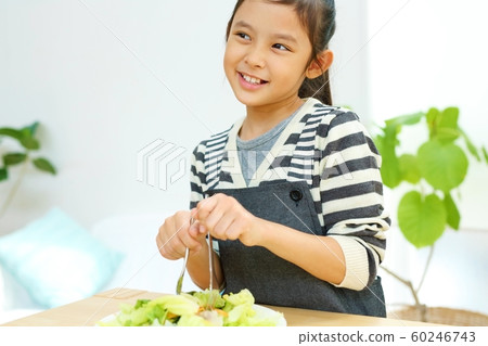 Image of a child helping with a meal in the kitchen Image of a child helping with a meal in the kitchen 60246743