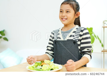 Image of a child helping with a meal in the kitchen Image of a child helping with a meal in the kitchen 60246744