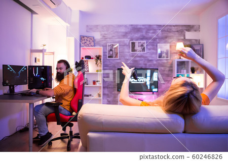 Back view of blond girl after losing at a online shooter game 60246826