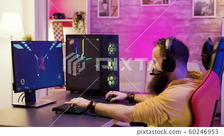 Bearded man playing online video games on his pc 60246953