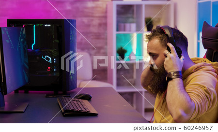 Concentrated man playing video games on pc in his room 60246957