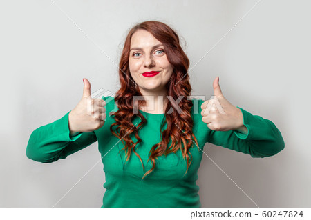 Young girl with red hair and red lipstick showing 60247824